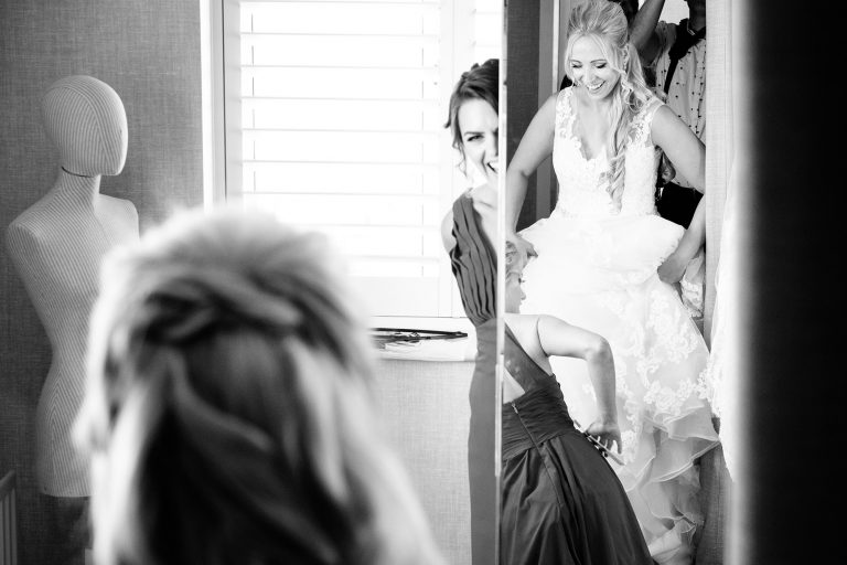 bride and bridesmaids dressing and laughing
