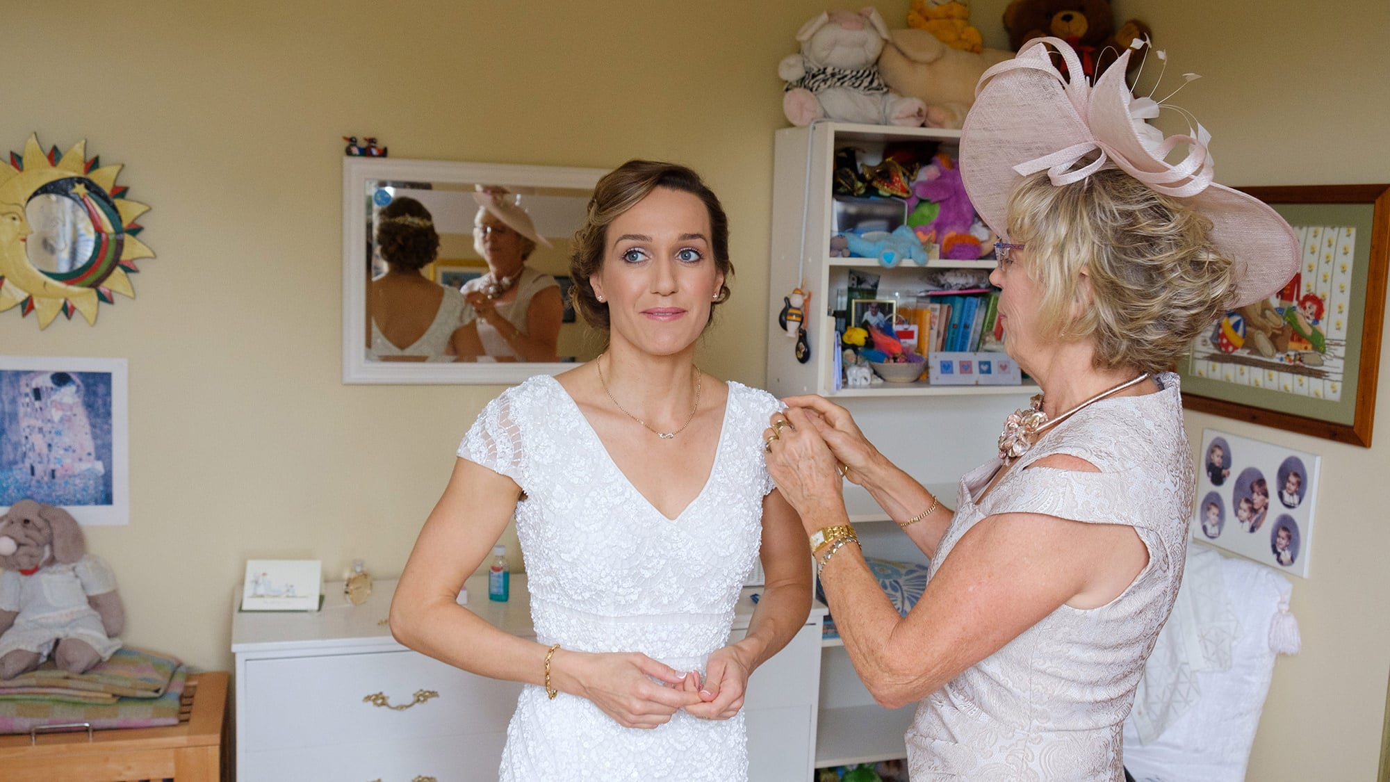mother helping bride dress